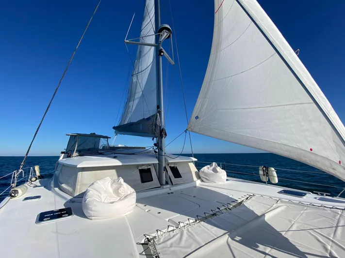 Carpe Aura Yacht Photos Pics 2018 Fountaine Pajot Helia 44 catamaran sailing on open sea under clear blue sky.