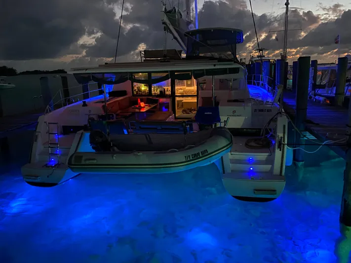 Carpe Aura Yacht Photos Pics Fountaine Pajot Helia 44 catamaran, 2018 model, illuminated at night with blue underwater lights.