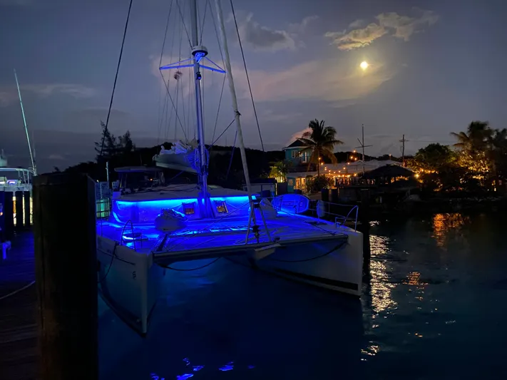 Carpe Aura Yacht Photos Pics Fountaine Pajot Helia 44 catamaran illuminated at night, 2018 model, under a moonlit sky.