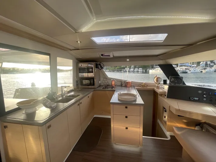 Carpe Aura Yacht Photos Pics Luxurious interior of 2018 Fountaine Pajot Helia 44 catamaran with modern kitchen and scenic views.