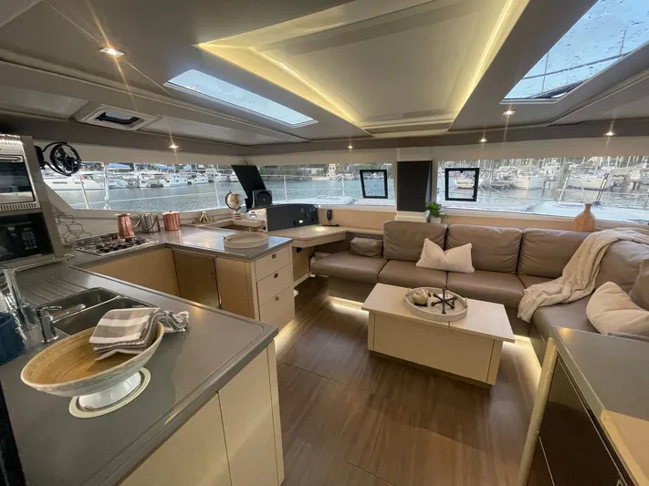 Carpe Aura Yacht Photos Pics Luxurious interior of 2018 Fountaine Pajot Helia 44 catamaran with modern kitchen and cozy seating area.