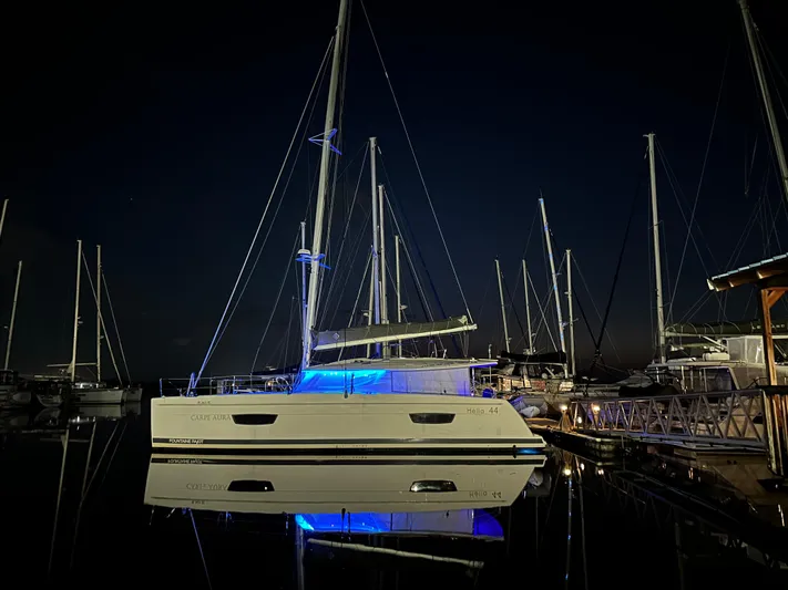 Carpe Aura Yacht Photos Pics 2018 Fountaine Pajot Helia 44 catamaran illuminated at night in a marina.