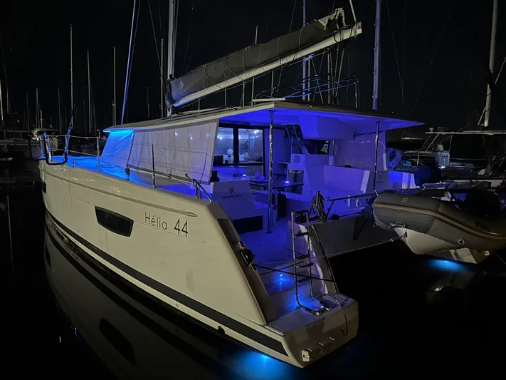 Carpe Aura Yacht Photos Pics Fountaine Pajot Helia 44 catamaran, 2018 model, illuminated at night in a marina.