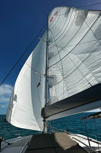 Carpe Aura Yacht Photos Pics Fountaine Pajot Helia 44 sailing yacht, 2018 model, with full sails against a clear blue sky.
