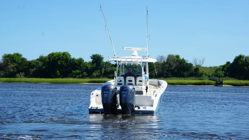  Yacht Photos Pics 2022 Cobia 350 Center Console boat on water with twin engines, lush greenery in background.