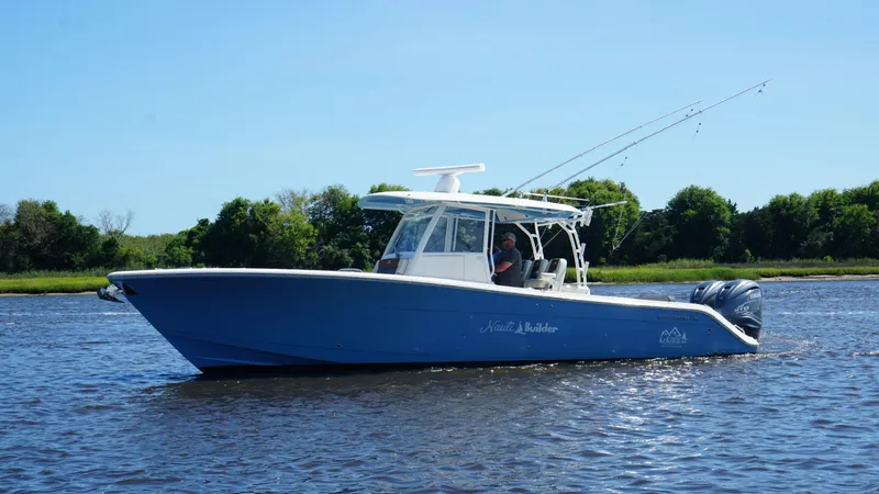  Yacht Photos Pics 2022 Cobia 350 Center Console boat on water, clear sky, lush green background.