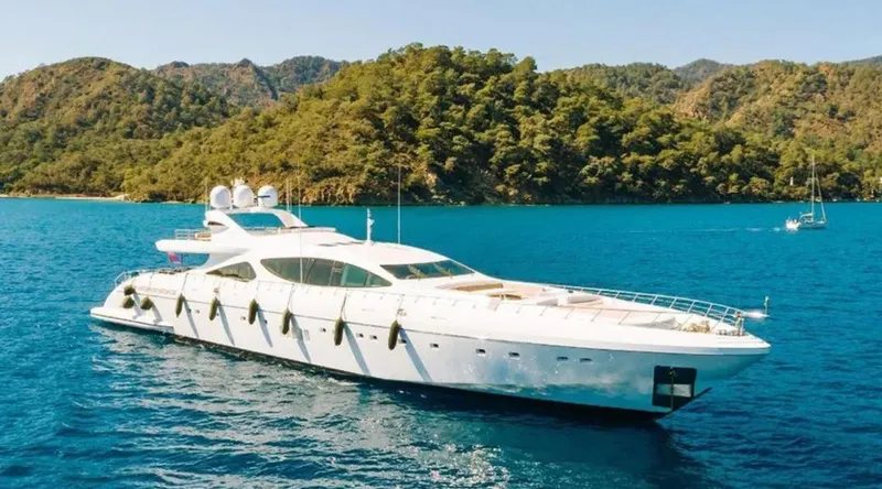  Yacht Photos Pics Luxurious 2009 Mangusta 165 yacht cruising in scenic blue waters near lush green hills.