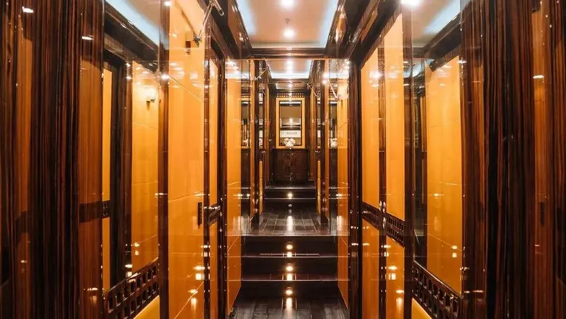  Yacht Photos Pics Luxurious interior hallway of 2009 Mangusta 165 yacht with warm lighting and elegant wood finishes.