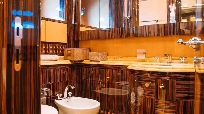 Yacht Photos Pics Luxurious bathroom interior on a 2009 Mangusta 165 yacht, featuring elegant wood finishes.