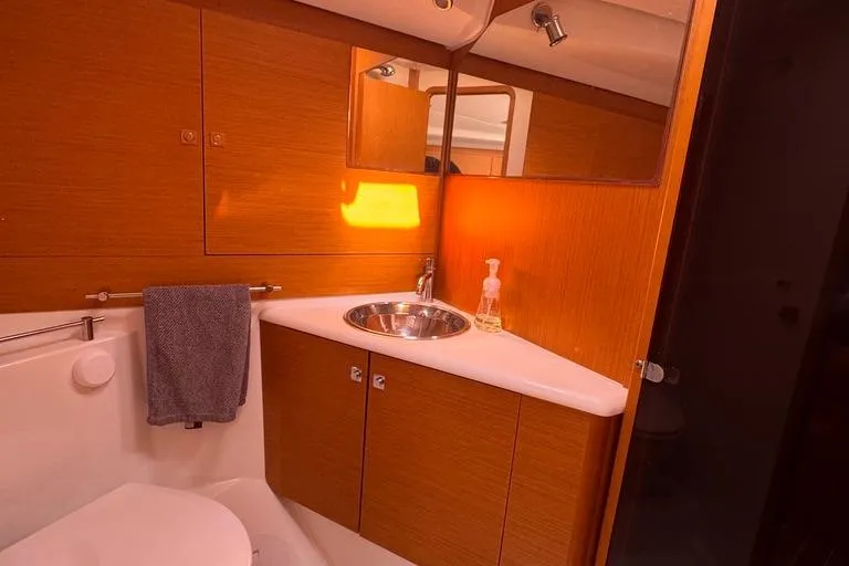  Yacht Photos Pics Bathroom interior of 2011 Jeanneau 50 DS yacht with wooden cabinetry and stainless steel sink.