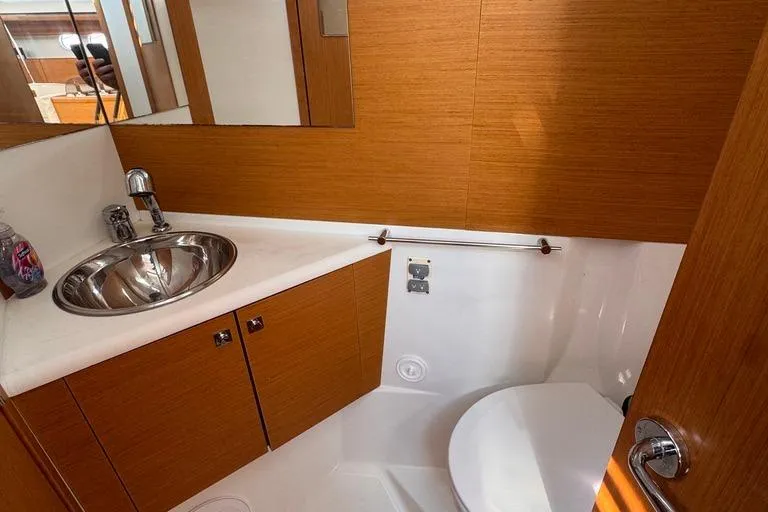  Yacht Photos Pics Luxurious 2011 Jeanneau 50 DS yacht bathroom with modern sink and wooden cabinetry.