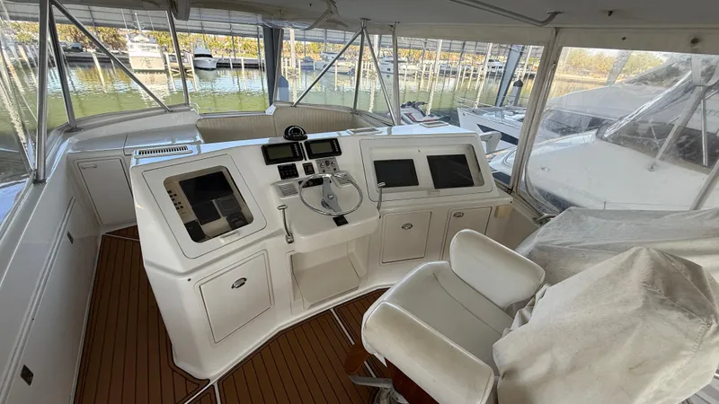 Steel Mahlin Yacht Photos Pics 2006 Ocean Yachts 57 Super Sport helm with navigation equipment and seating, docked at marina.