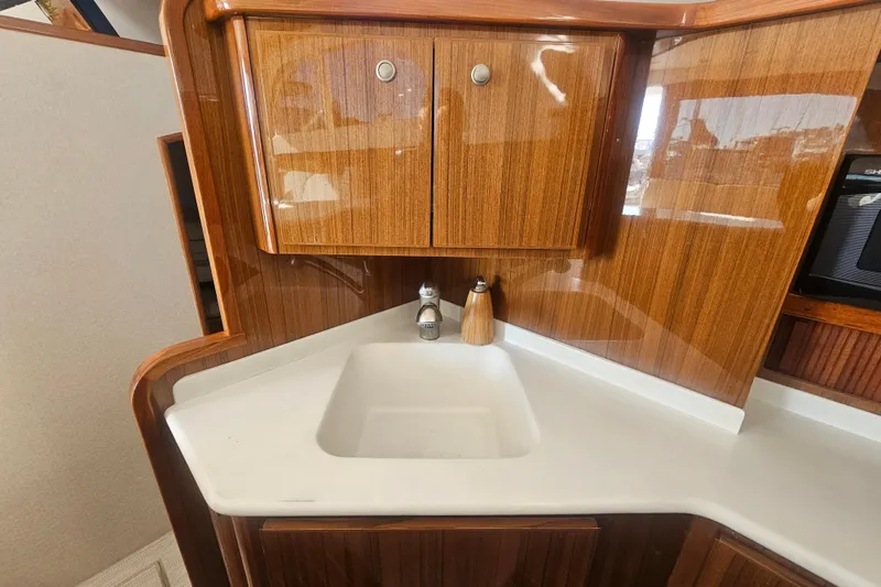 Team Turbo Yacht Photos Pics 2013 Viking 42 Convertible yacht interior with wooden cabinetry and white sink.