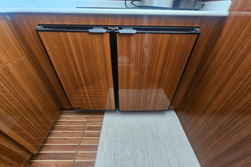 Team Turbo Yacht Photos Pics Wood-paneled kitchen area in 2013 Viking 42 Convertible yacht, featuring dual Nova Kool refrigerators.
