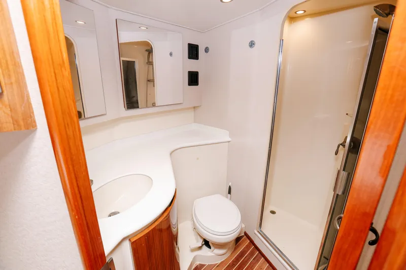 Team Turbo Yacht Photos Pics Bathroom interior of 2013 Viking 42 Convertible yacht with shower and wooden accents.