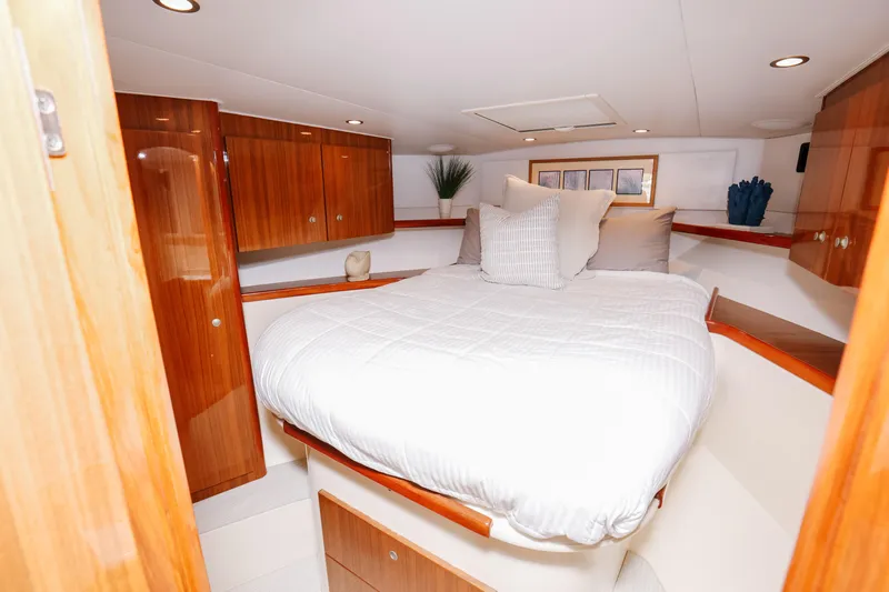 Team Turbo Yacht Photos Pics Luxurious bedroom interior of 2013 Viking 42 Convertible yacht with elegant wood finishes.
