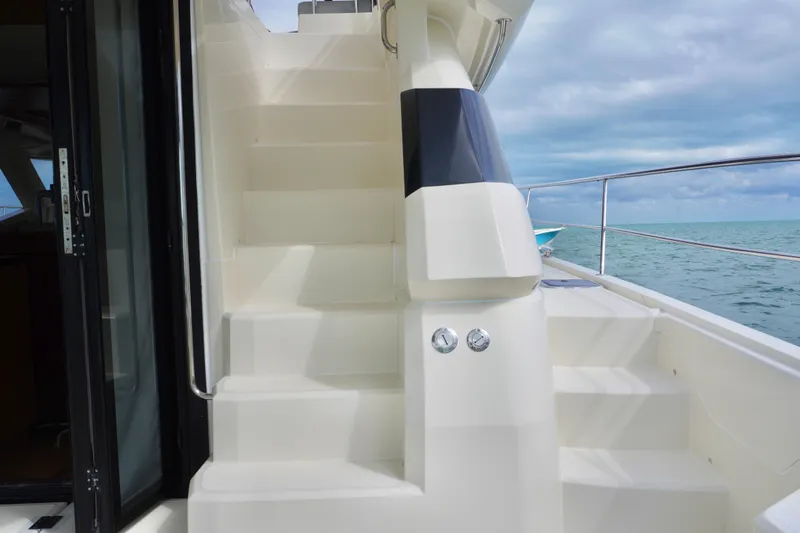 Sandals Yacht Photos Pics Staircase on 2017 Aquila 44 Yacht with ocean view in background.