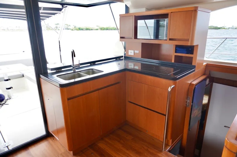 Sandals Yacht Photos Pics Luxurious kitchen interior of 2017 Aquila 44 Yacht with wooden cabinetry and modern appliances.