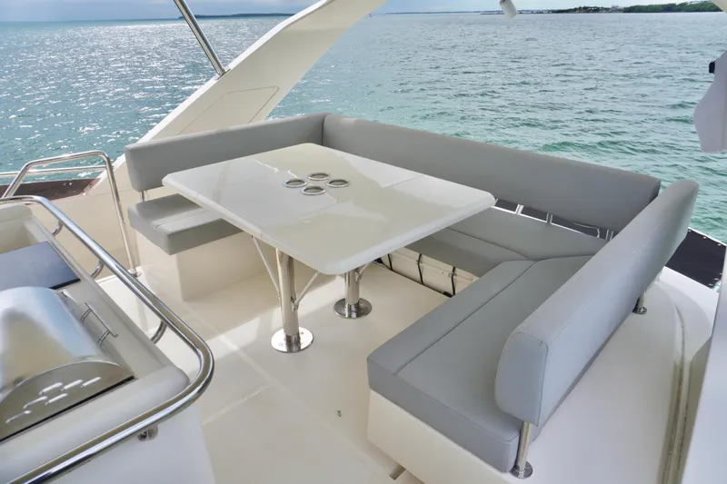 Sandals Yacht Photos Pics 2017 Aquila 44 Yacht with elegant outdoor seating and table, overlooking serene ocean waters.