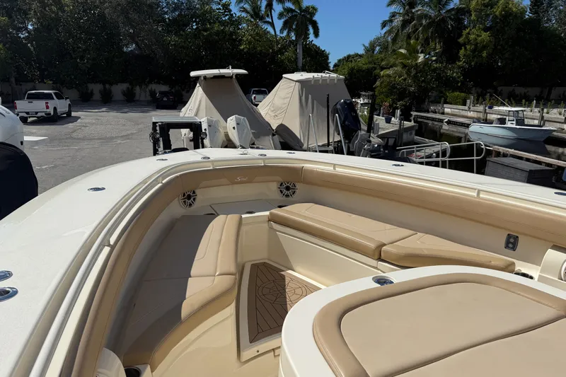  Yacht Photos Pics 2022 Scout 355 LXF boat interior with beige seating and docked boats in background.