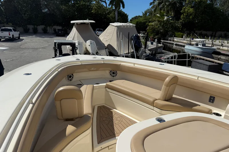  Yacht Photos Pics 2022 Scout 355 LXF boat interior with beige seating and wood accents.