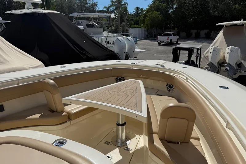  Yacht Photos Pics 2022 Scout 355 LXF boat interior with tan seating and triangular table.