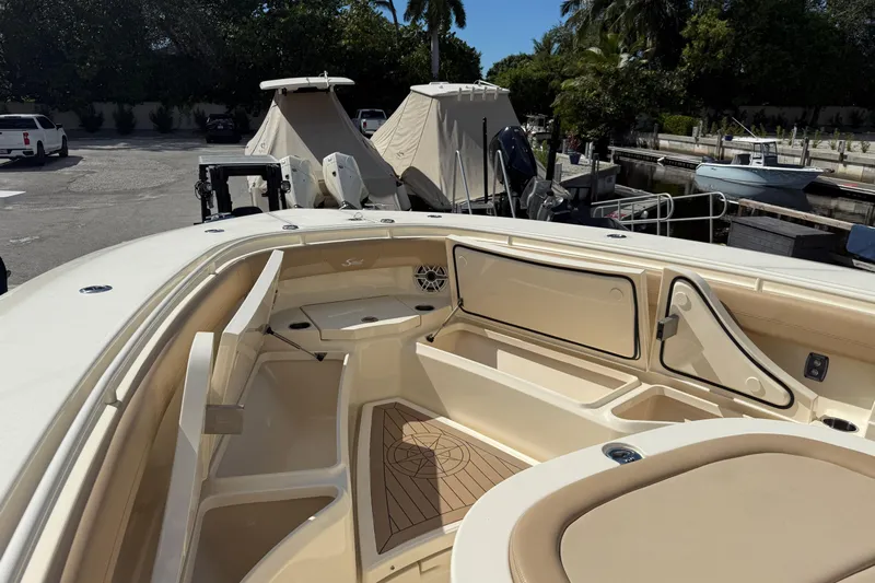  Yacht Photos Pics 2022 Scout 355 LXF boat interior with seating and storage, docked in a marina.
