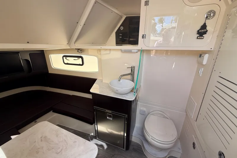  Yacht Photos Pics 2022 Scout 355 LXF cabin interior with seating, sink, and toilet.