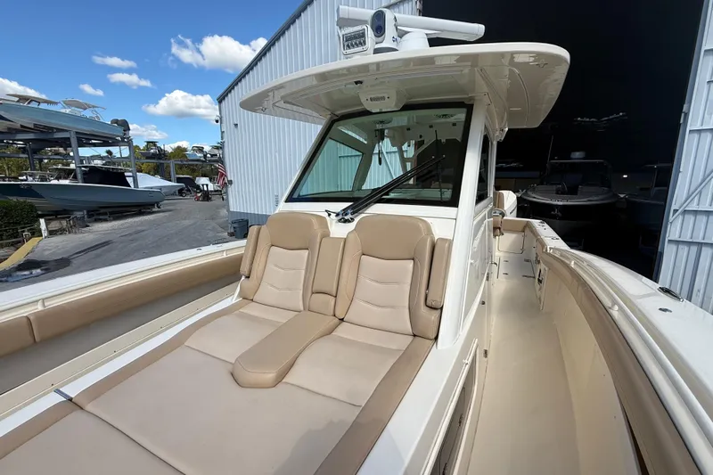  Yacht Photos Pics 2022 Scout 355 LXF boat with luxurious seating and sleek design in a marina setting.