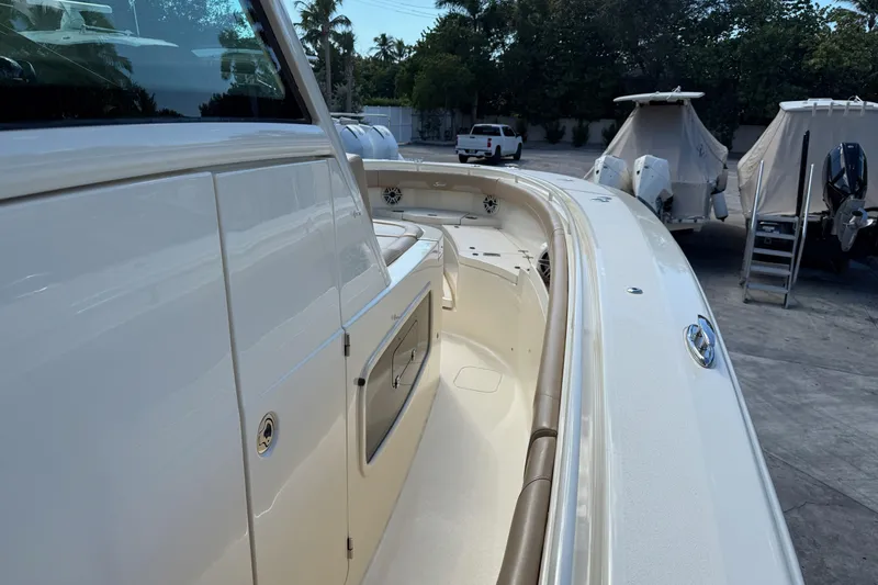  Yacht Photos Pics 2022 Scout 355 LXF boat, sleek design, docked with covered vessels in the background.
