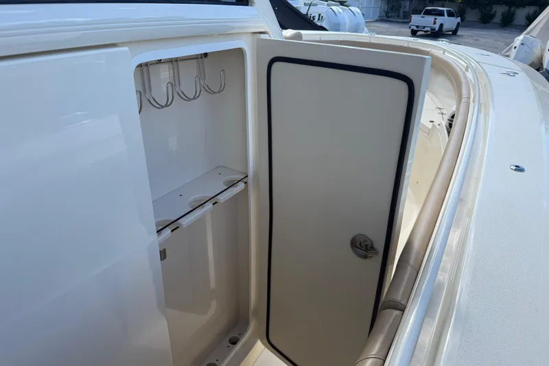  Yacht Photos Pics 2022 Scout 355 LXF boat storage compartment with hooks and door open.