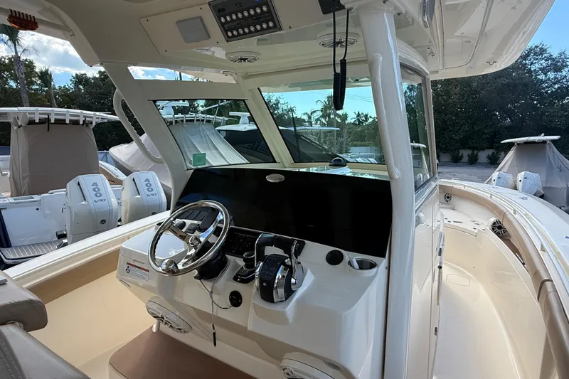  Yacht Photos Pics 2022 Scout 355 LXF boat interior with steering wheel and control panel.