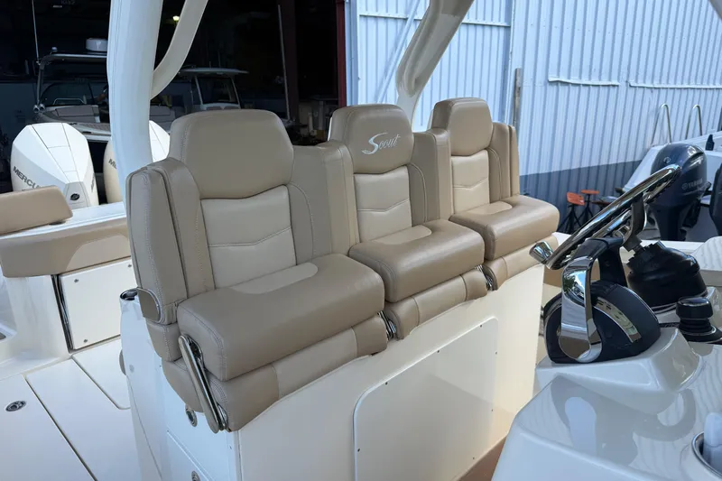  Yacht Photos Pics 2022 Scout 355 LXF boat interior with beige leather seating and steering wheel.