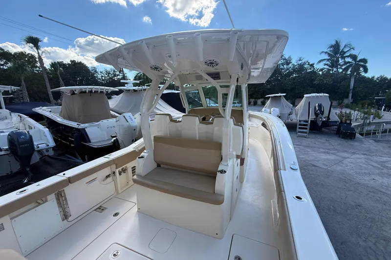  Yacht Photos Pics 2022 Scout 355 LXF boat with seating and canopy, docked under a clear sky.