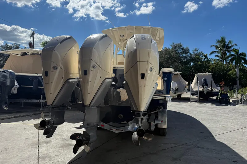  Yacht Photos Pics 2022 Scout 355 LXF boat with triple outboard engines in a sunny marina.