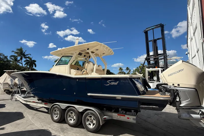  Yacht Photos Pics 2022 Scout 355 LXF boat on trailer, blue hull, Mercury engines, sunny day.