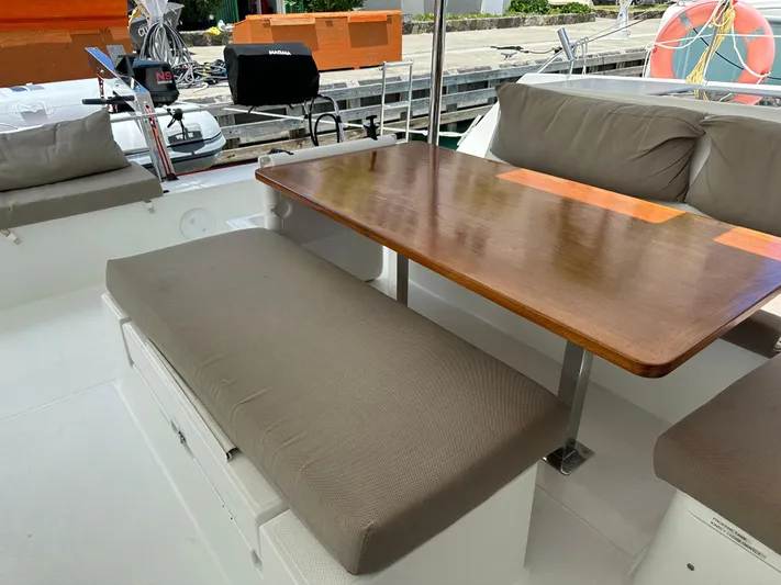 Goin' Coastal Yacht Photos Pics Fountaine Pajot Helia 44 Evolution 2018 yacht cockpit with cushioned seating and wooden table.