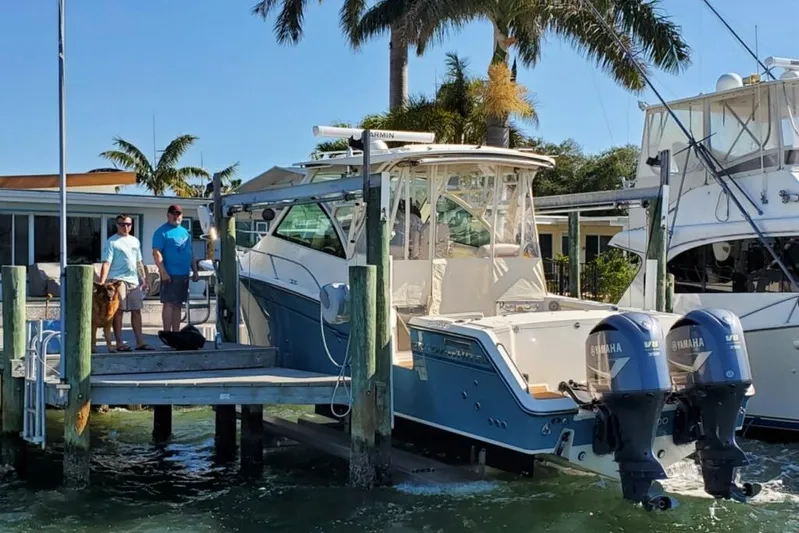 Rising Sun Yacht Photos Pics 2018 Grady-White Express 330 boat docked with two people and a dog nearby.