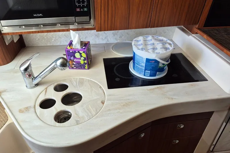 Rising Sun Yacht Photos Pics Compact kitchen area in a 2018 Grady-White Express 330 boat with sink and stove.