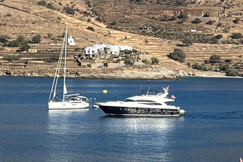 Yacht Photos Pics Two yachts, including a 2012 Princess 72 Motor Yacht, anchored in a scenic coastal bay.