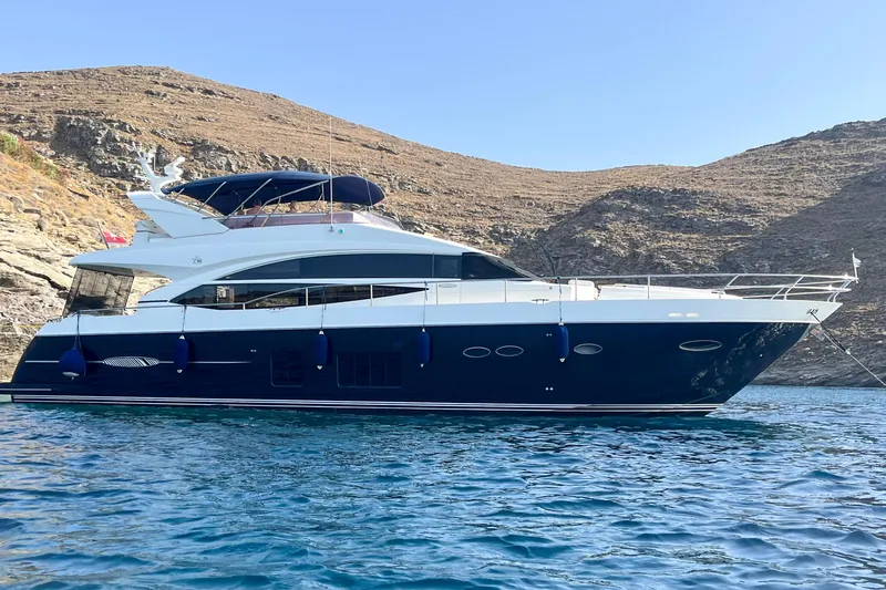  Yacht Photos Pics 2012 Princess 72 Motor Yacht anchored near rocky coastline under clear blue sky.