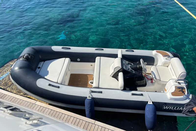  Yacht Photos Pics Inflatable boat docked beside a 2012 Princess 72 Motor Yacht on clear blue water.