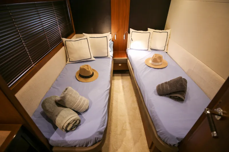  Yacht Photos Pics Twin cabin interior of 2012 Princess 72 Motor Yacht with hats and towels on beds.