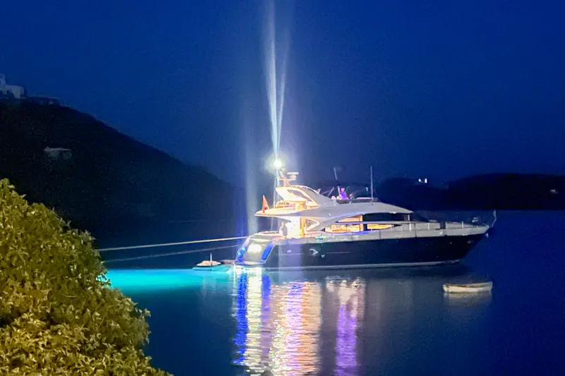  Yacht Photos Pics Luxurious 2012 Princess 72 Motor Yacht illuminated at night on calm waters.