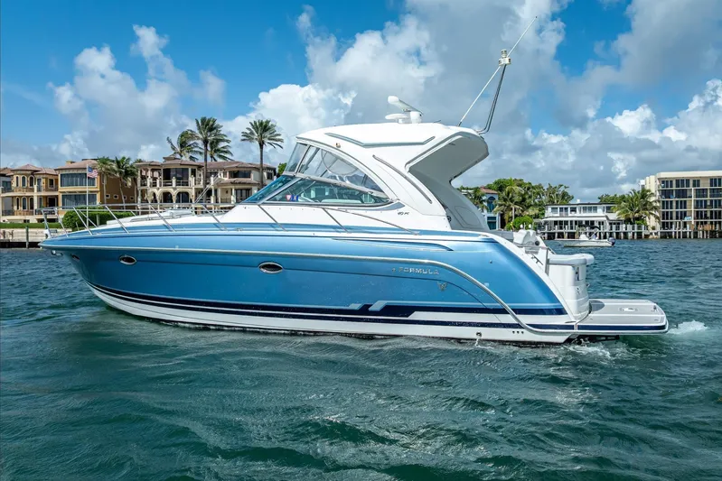  Yacht Photos Pics 2022 Formula 40 Performance Cruiser on water, blue hull, luxury waterfront homes in background.