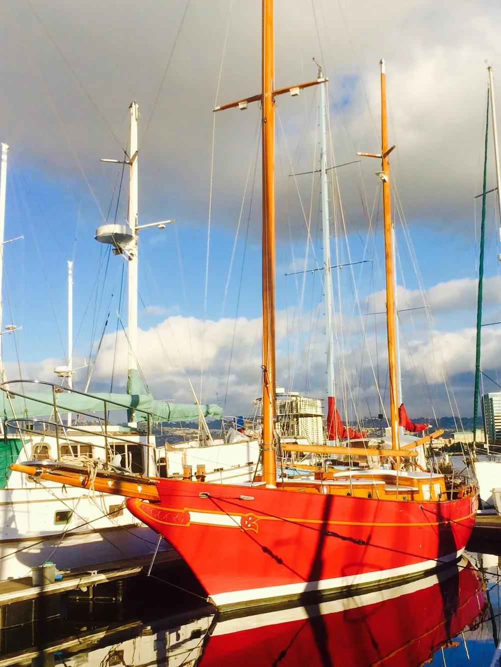 Red 1971 Formosa 41 sailboat docked at marina under cloudy sky.