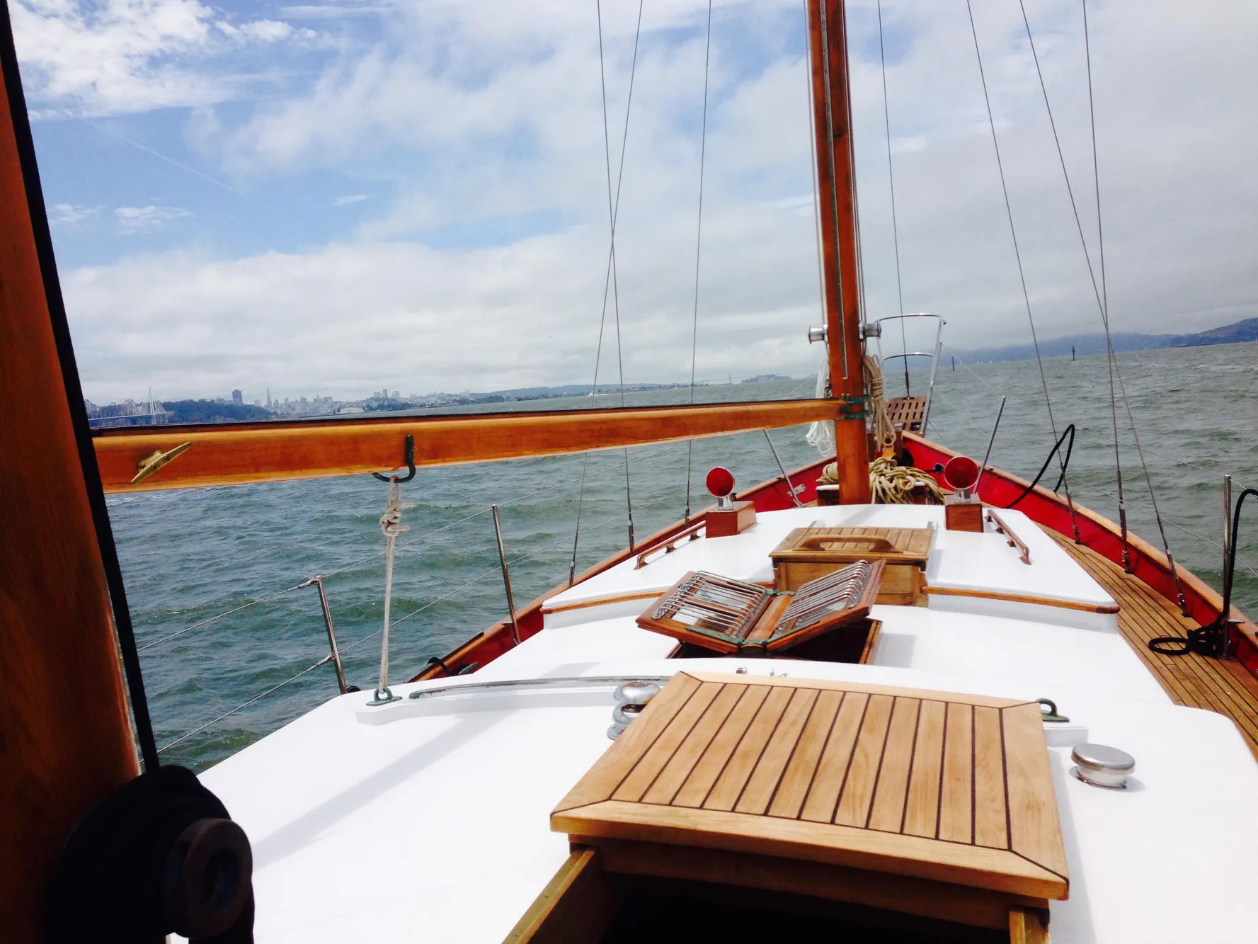 Sailing on a 1971 Formosa 41 yacht, wooden deck, open sea, clear sky.