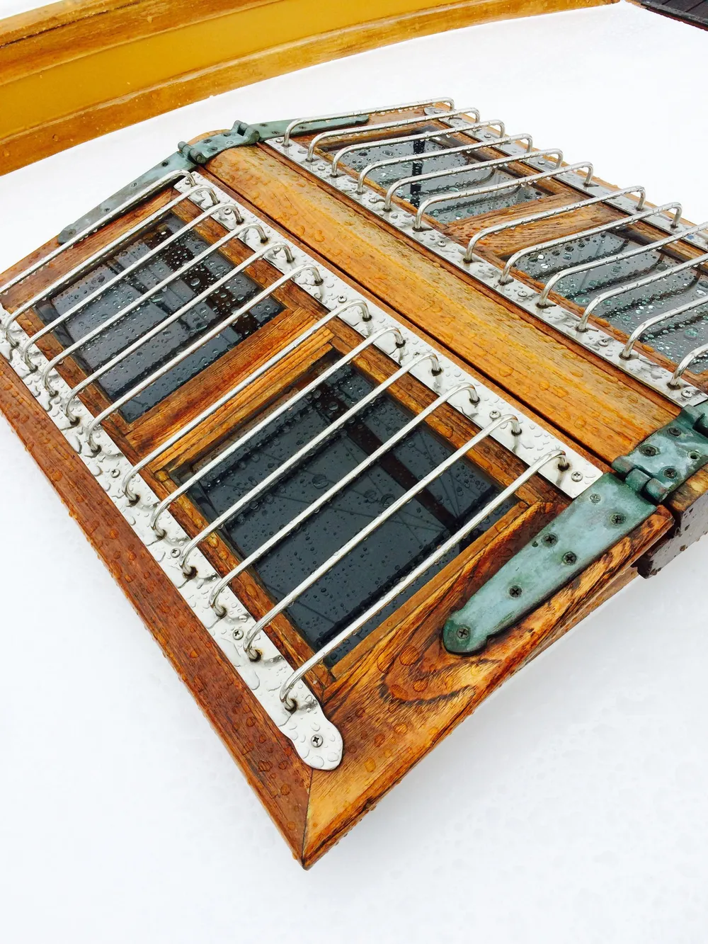 Wooden hatch with metal bars on a 1971 Formosa 41 sailboat.