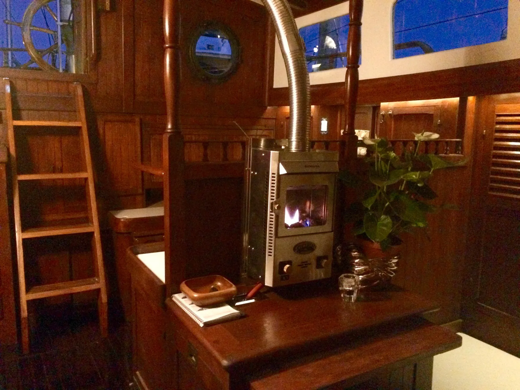 Interior of a 1971 Formosa 41 sailboat with wooden decor and a cozy stove.