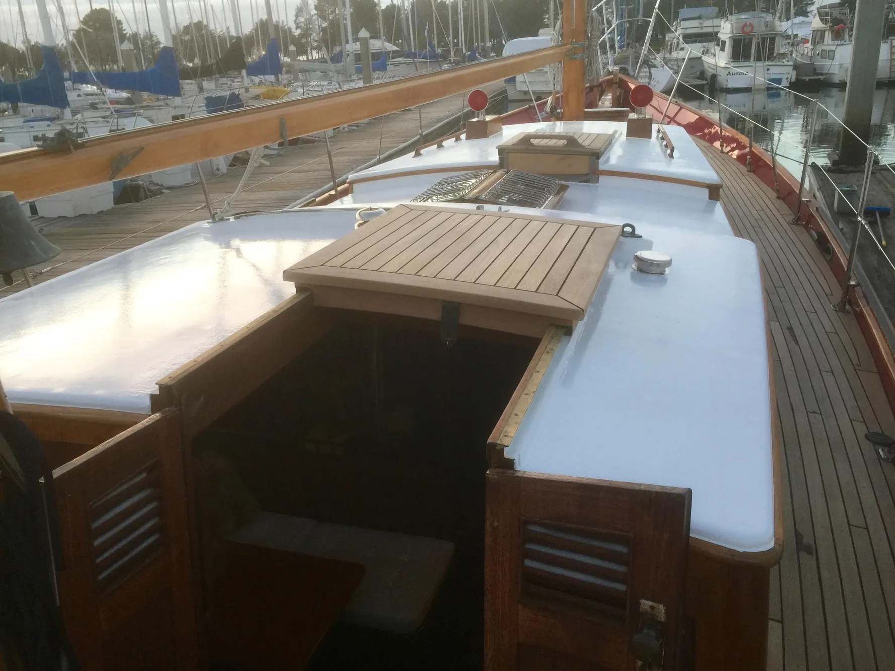 1971 Formosa 41 sailboat deck with wooden hatch and marina background.